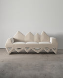 Troy Smith Lighting Sofa featuring a sculptural white upholstered form with geometric triangular detailing. A statement designer sofa for contemporary luxury interiors.