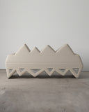 Troy Smith Lighting Sofa featuring textured white upholstery and a dramatic geometric silhouette. The triangular base detailing creates a bold statement for modern interiors.