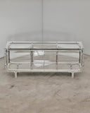 Troy Smith Looking Glass Cabinet featuring a reflective metal frame with transparent glass doors and shelving. A sculptural designer storage cabinet for contemporary luxury interiors.