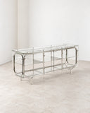 Contemporary Looking Glass cabinet featuring a transparent glass structure and reflective chrome-finish metal framing with geometric supports. The open, linear construction creates a refined display and storage piece with a minimalist architectural aesthetic.