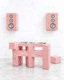 YONT Brutalist DJ Deck in pink featuring a chunky geometric console with squared legs, a solid block-like structure, and a textured monochromatic finish. Its architectural form reimagines DJ equipment as a sculptural centrepiece for contemporary music and hospitality spaces.