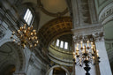 Grand interior of a cathedral with ornate chandeliers and detailed architecture.