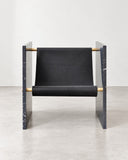 Adri lounge chair featuring a black upholstered seat and backrest supported by a polished metal frame with angular armrests. The combination of dark upholstery and reflective metal creates a refined contemporary seating design.