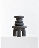 LS-01 volcanic rock sculpture featuring stacked rounded forms and a compact arched base with a rough, porous surface. The dark natural stone texture gives the abstract collectible object a bold sculptural presence.