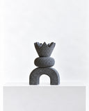 LS-06 volcanic rock sculpture featuring a crown-like pointed top, rounded middle element, and arched base. The dark porous stone finish and stacked geometric forms create a distinctive contemporary collectible object.