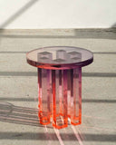 Round acrylic dining table featuring a deep red to orange gradient fade