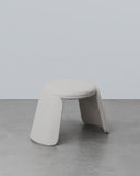 Minimalist stool with a curved design on a gray floor and light gray background